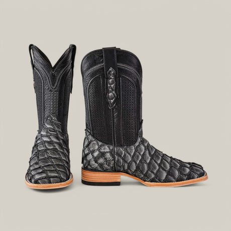 The Exotic Pirarucu Fish - Newspaper features black cowboy boots made from fish leather with a reptile texture, square toe design, classic leather details, elevated heel, and natural-colored soles.