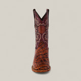 The Jonh - Cogñac - Square Toe boot from the Last Call collection is shown front-facing, with a brown and tan crocodile-textured foot and an ornate, reddish-brown shaft featuring decorative stitching on a plain background.
