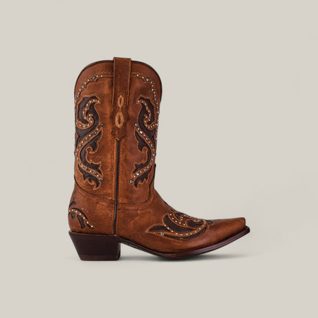 The Dolly - Brown - Snip Toe boot, featuring decorative embroidery and metal studs, is shown in profile on a light beige background—part of the Last Call collection.