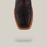 Close-up of the Exotic Python - Blackcherry - Square Toe boot, highlighting its dark textured python skin, brown leather trim, and intricate stitching from the Platinum Collection against a light background.