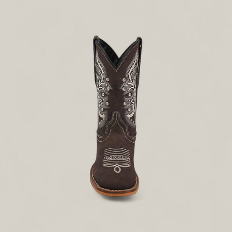 The Amara Suede Oxford - Square Toe Kids Boot, shown from the front against a plain light background, features dark brown suede with white embroidery and decorative stitching, highlighting craftsmanship found in fine square-toe shoes.