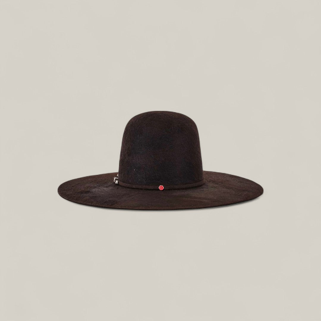 The 10X Grizzly - Tacchino is a wide-brimmed, dark brown open crown felt hat with a rounded crown, featuring a small silver detail and a tiny red accent on the band, shown against a plain beige background.