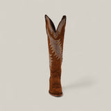 The Daisy Camel - Tall Shaft - Snip Toe features brown suede, white embroidery, and a pointed toe, standing upright against a plain background—an ideal choice to elevate any women’s fashion boot collection.