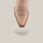 A close-up of the pointed toe of Tessa Champagne Mid Shaft snip toe boots, featuring beige color with brown embroidered patterns and a brown sole, set against a plain off-white background.