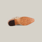 The Tessa Champagne Mid Shaft Snip Toe boot is shown on its side, highlighting its decorative floral-engraved sole and stitched leather heel—ideal for women who value both style and craftsmanship.