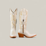 The Kellie Frost White Leather Sole boots feature a tall shaft, snip toe design, tan decorative stitching, wooden heels, and a side zipper for modern style and classic western appeal.