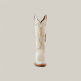 The Kellie Frost White Leather Sole Tall Shaft Snip Toe boot is shown from the front, highlighting its white leather and intricate tan stitching, set against a plain beige background.