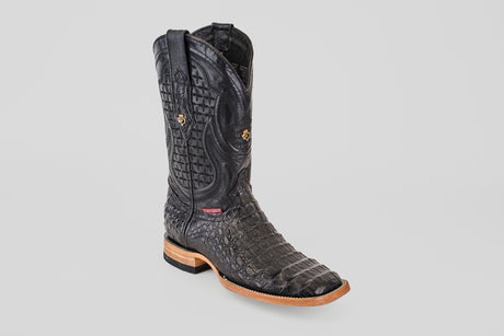 The Exotic Caiman Horn Back - Black - Square Toe boot, featuring textured caiman leather with a crocodile pattern, tan sole, and decorative stitching, is displayed against a plain light gray background.