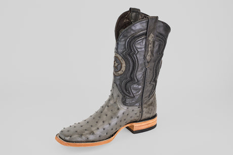 The Exotic Full Quilt Ostrich - Gray - Square Toe boot features decorative stitching, star detail on the shaft, textured ostrich leather, a wooden heel, and is displayed solo against a plain light gray background.