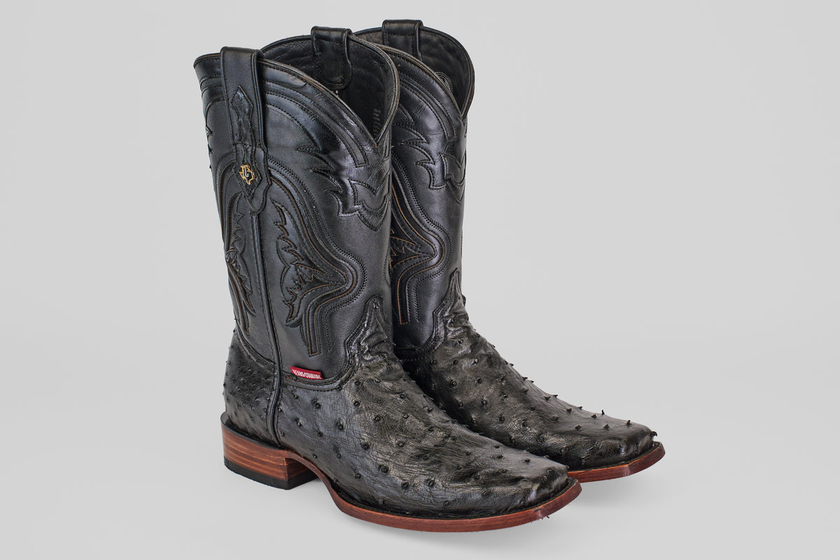 The Exotic Ostrich - Black - Rodeo Toe cowboy boots feature black ostrich leather, decorative stitching, a medium shaft, and wooden heels—ideal for upgrading your western look—shown on a light gray background.
