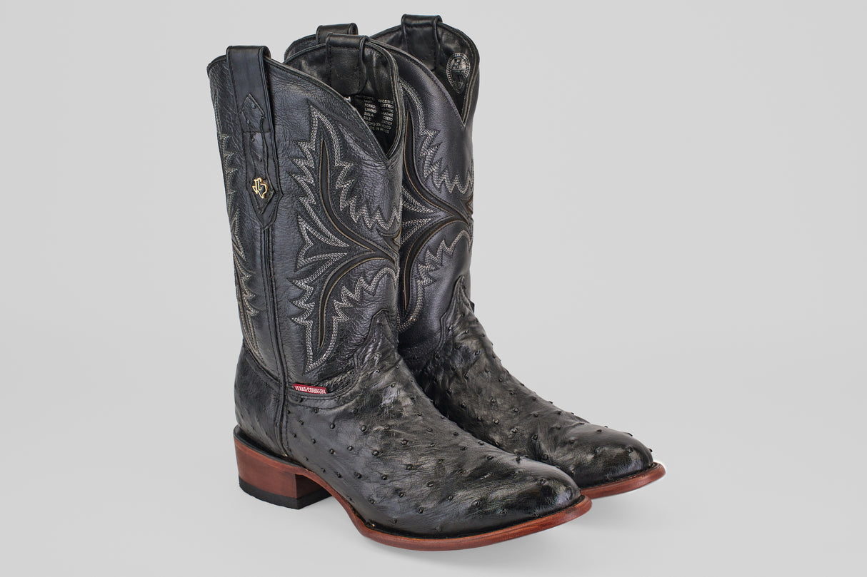 A pair of Exotic Full Quilt Ostrich boots in black with round toes and textured leather, featuring decorative stitching and brown wooden soles, displayed against a plain light gray background.