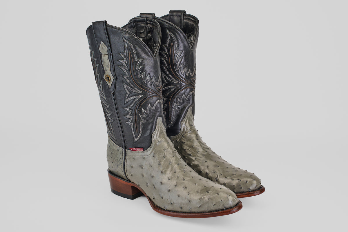 The Austin - Oxford - Round Toe men's cowboy boots feature gray and black ostrich leather, decorative stitching, brown soles, and a round toe design, displayed on a plain white background.