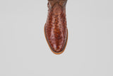 A close-up, top-down view of the Austin - Tabaco - Roper Toe men’s cowboy boot in brown ostrich leather, showcasing its texture and stitching on a plain white background.