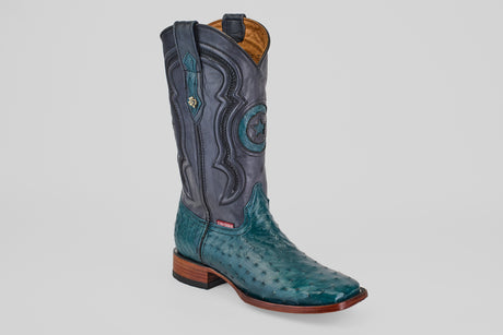 The Austin - Gasoline Green Square Toe men's western boot features a turquoise ostrich leather foot, dark blue leather shaft with decorative stitching, square toe, and wooden heel, shown on a plain white background.
