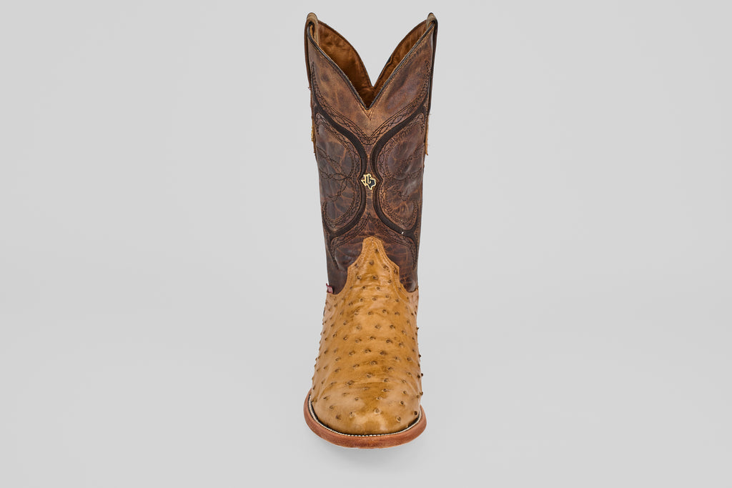 The Austin - Antique - Roper Toe cowboy boot features a light tan, textured lower section and a dark brown, decorative upper shaft, displayed from the front against a plain white background.