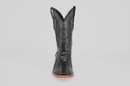 The Austin Leg - Black - Square Toe boot features decorative stitching, a star emblem on the shaft, and a light tan sole. Photographed from the front on a plain light gray background, it's ideal for square toe boot enthusiasts.