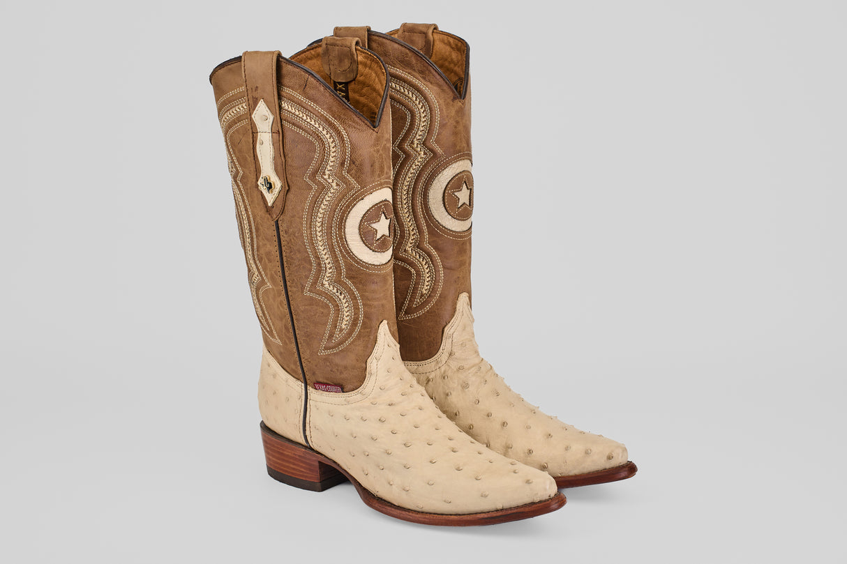 The Austin - Bone - Snip Toe cowboy boots feature a light bone ostrich leather foot, brown stitched shafts with star designs, snip toes, pull straps, and stylish wooden heels.