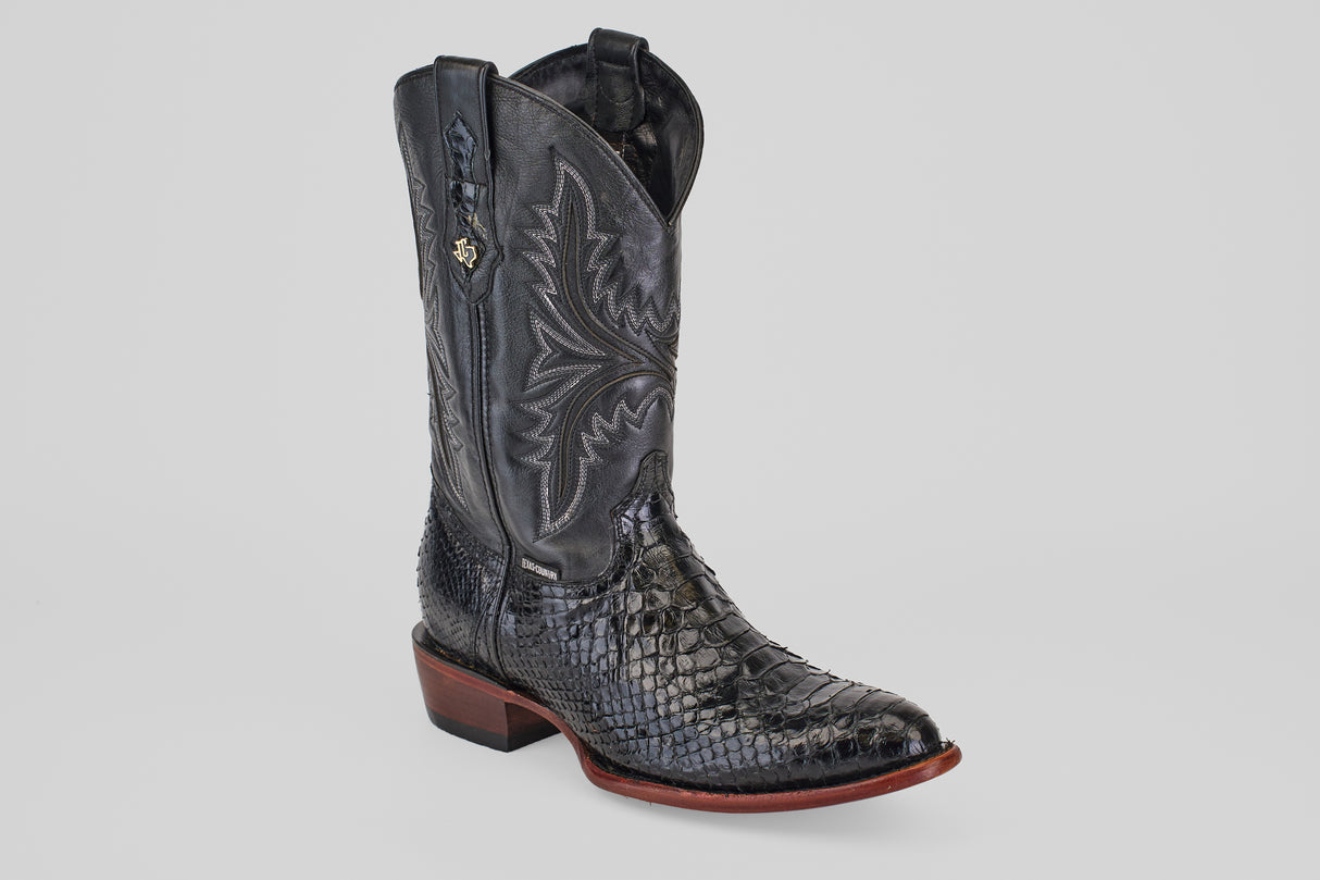 The Tanner - Black - Round Toe cowboy boot features a textured black snakeskin pattern, decorative shaft stitching, a low wooden heel, and a round toe, displayed against a plain light gray background.