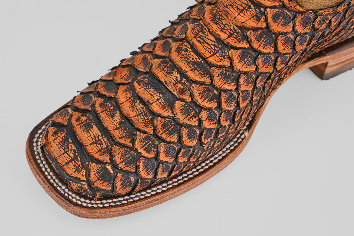 Close-up of the toe of the Tanner Jumbo – Chestnut – Square Toe boot, crafted from textured, python-scale leather with detailed white stitching along the sole.