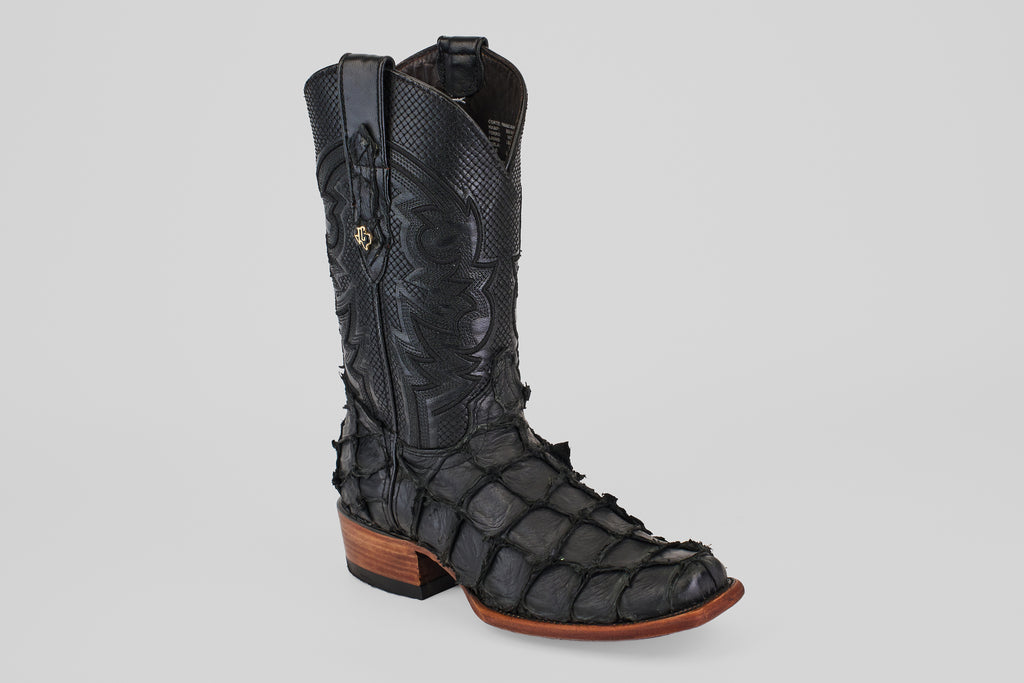 The Conor - Matte Black - Narrow Square Toe cowboy boot features textured fish leather, detailed shaft stitching, and a wooden heel, shown as a single black boot on a plain light gray background.