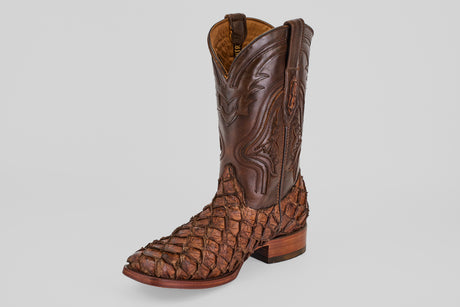 The Conor - Brown - Rodeo Toe boot features decorative stitching on the shaft and a textured, scaly pattern on the foot, displayed against a plain light gray background.