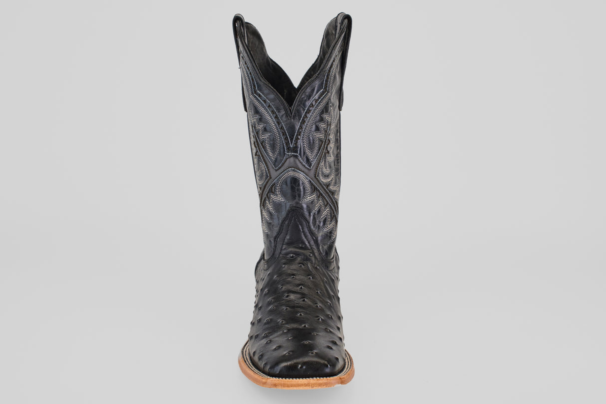 A single Ostrich Black - Embossed Leather - Square Toe (E424) cowboy boot with textured details and decorative stitching, shown from the front on a plain light gray background. Features a light brown sole and slightly pointed toe.