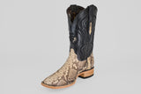 The Tanner - Matte Natural - Square Toe cowboy boot features a tan and brown snakeskin-patterned foot, a tall black leather shaft with decorative stitching, and is displayed on a plain gray background.