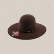 The 4X - Chocolate - TC Hat is a felt Western hat in dark brown, with a wide brim, simple black band, and attached tag, shown against a plain light background.