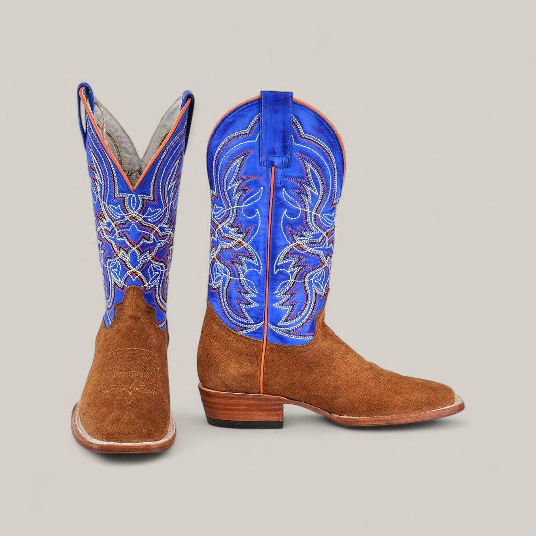 The Bronson - Gold - Square Toe mens suede boots feature a brown foot, bright blue shaft, and detailed white and orange stitching. Displayed on a plain light background, one boot stands upright while the other lies on its side.