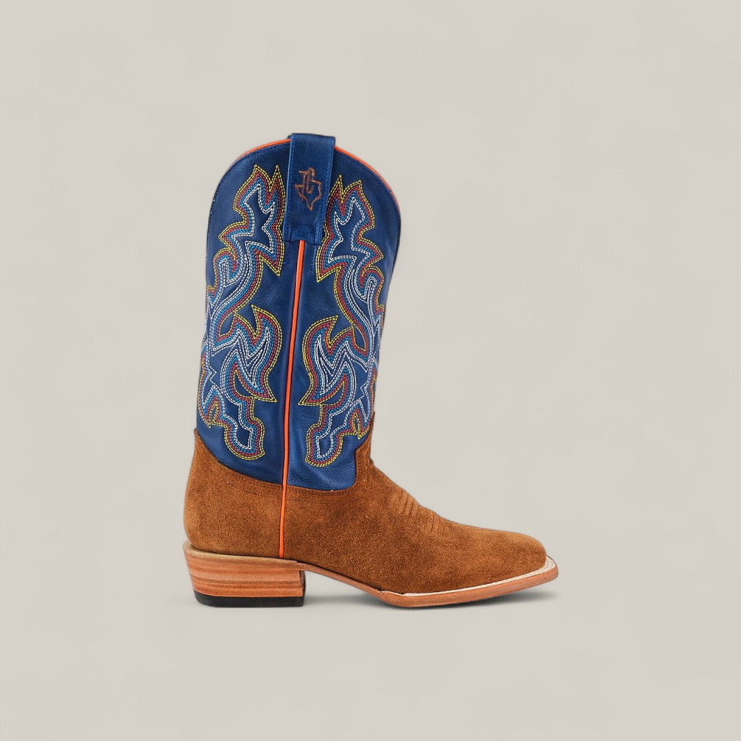 The Buck - Camel - Square Toe is a mens suede boot with a brown foot and a tall, royal blue shaft with colorful embroidery, featuring a stylish square toe and low wooden heel.