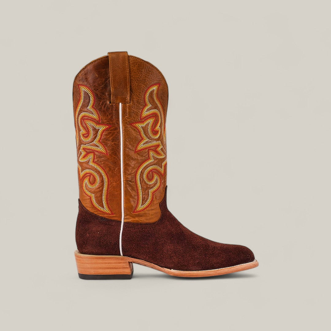 The Dusty - Classic Brown - Roper Toe boot features a brown suede finish, square toe, embroidered leather upper, pull tab, and wooden heel—an ideal choice for the modern man. Displayed on a plain light background.