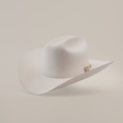 The 100X Independecia White is a luxurious cowboy hat made from full beaver fur. Featuring a broad brim, a slightly creased crown, and small decorative detail on the side, it rests elegantly against a plain light background—a true emblem of premium western headwear.