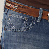 Close-up of a person wearing Mens Wrangler 20X No. 42 Vintage Bootcut Jeans - 1042MWXLB in premium denim with detailed stitching, paired with a decorative brown leather belt and partially visible metal buckle against a light, neutral background.
