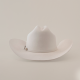 The 100X Independencia White is a luxurious cowboy hat made of full beaver fur, featuring a curved brim and a pin on the band, set against a plain light gray background.