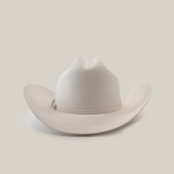The 500X Superior White is a luxurious belly beaver fur cowboy hat with a slightly curved brim and distinct crown crease. Set on a plain white background, it boasts an elegant decorative band around the base of the crown.