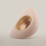 The 6X Country Belly is a plush, cream egg-shaped chair made from premium sheep wool. It features a large oval cutout showcasing a patterned interior and circular seating. Its minimalist modern design stands out against a white background.