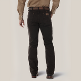 A person seen from the back is wearing a brown long-sleeve shirt and Wrangler Cowboy Cut Slim Fit Jeans (0936KCL) in dark brown with pockets and button details, accessorized with a leather belt. They stand against a light, neutral background.