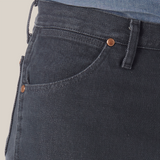 Close-up of someone in Wrangler Cowboy Cut Slim Fit Jeans - 0936CHG, featuring dark denim, visible stitching, and copper rivets on the pocket; paired with a tucked-in blue denim shirt to highlight premium denim quality.